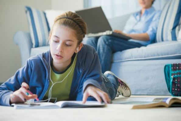 Mixed race girl with mp3 player doing homework